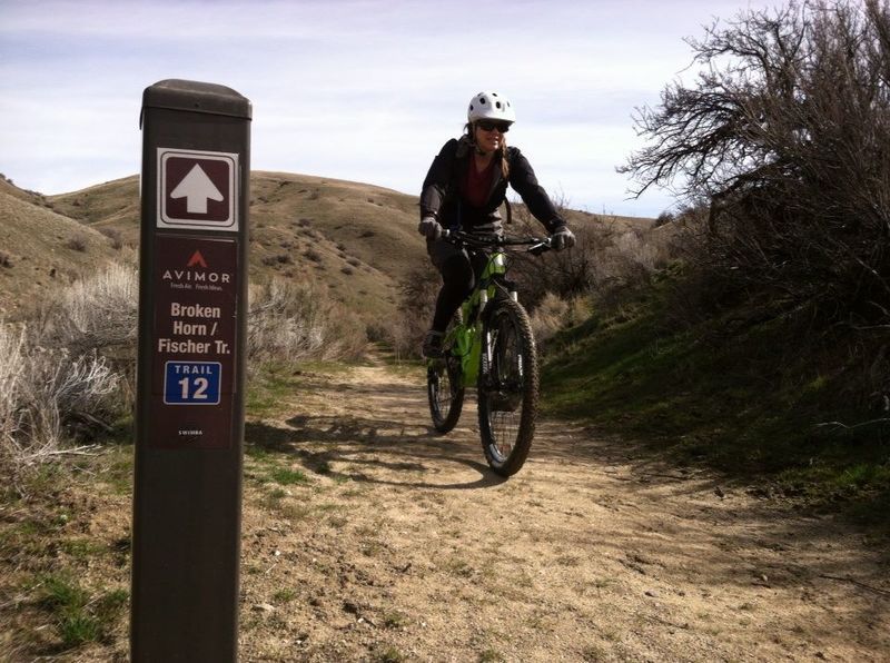 Mountain biker passing an Avimor trail marker
